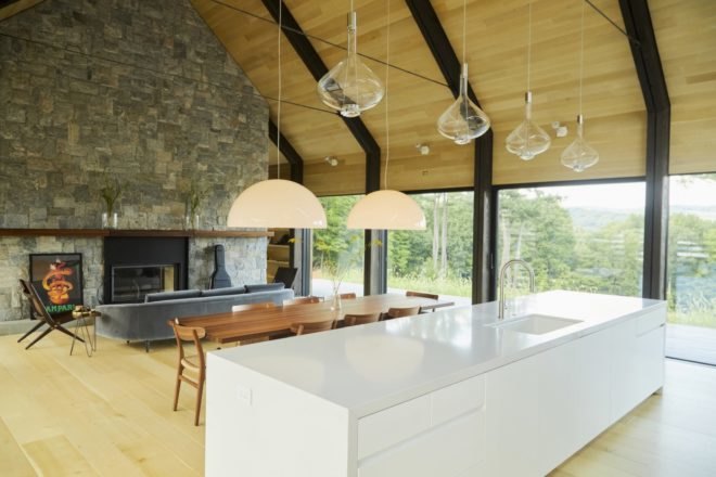 open plan kitchen, living and dining area with white kitchen island and timber ceilings