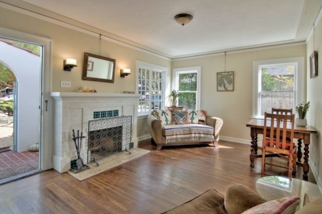 tan living room with white fireplace and small sofa