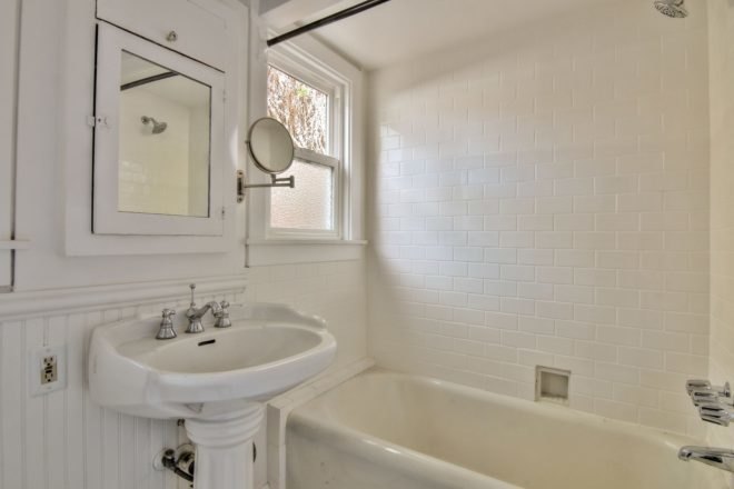 all white bathroom with tub/shower and sink