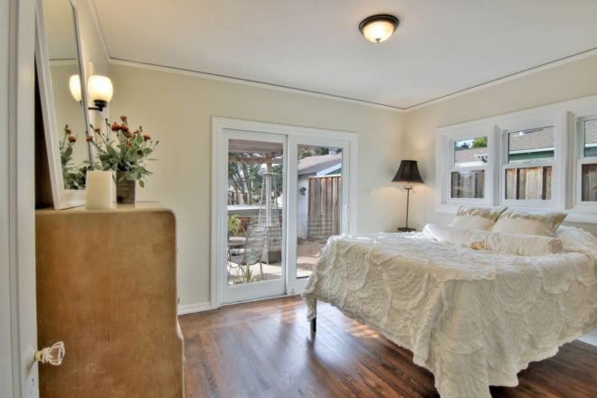 bedroom with white bed and large glass door