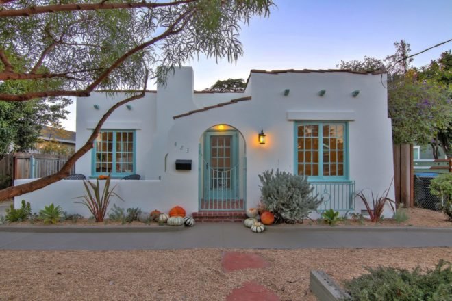 white bungalow with teal windows and front door