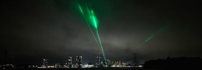 green laser lights above a city skyline