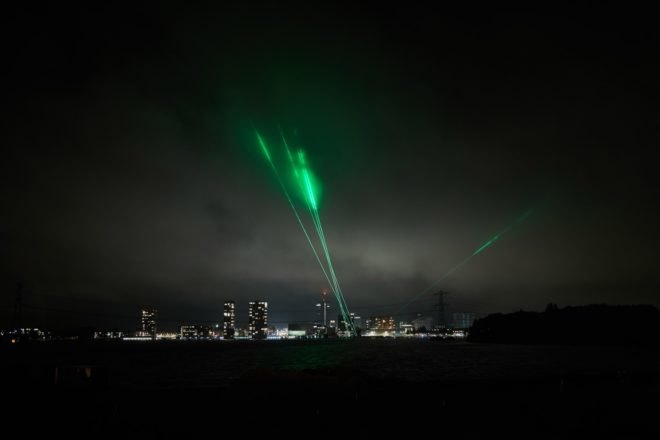 green laser lights above a city skyline