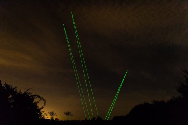 green laser lights in a dark sky