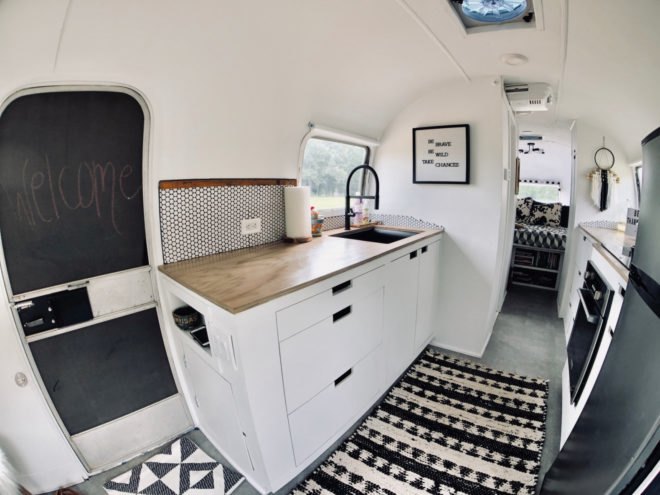 a kitchen with a black and white tiled floor