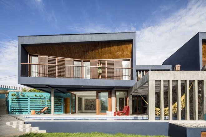 person standing on balcony of timber home