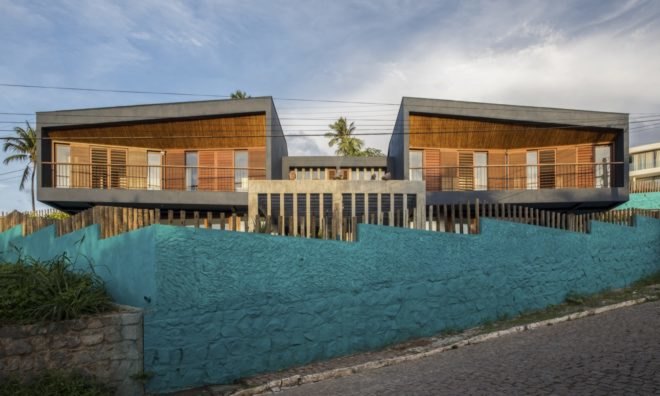 timber homes with bright blue jagged fence