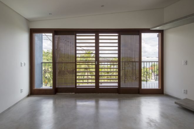white room with windows covered in timber screens