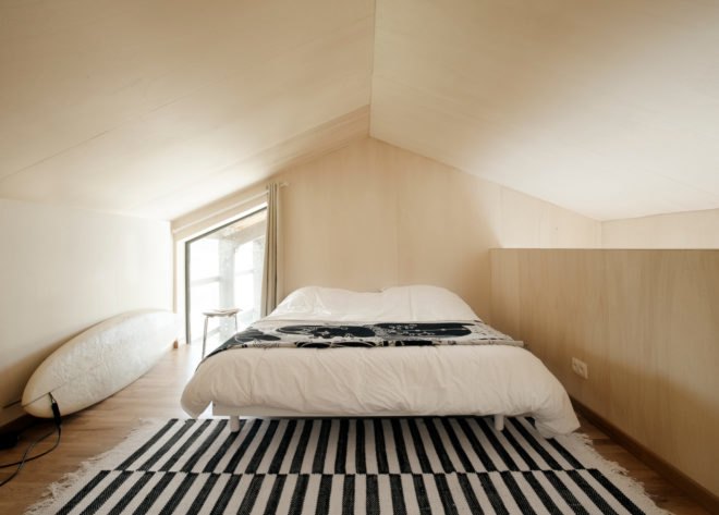 bedroom with natural wood paneling and striped rug
