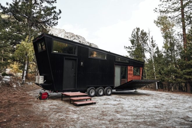 black RV with slanted roof and a front deck