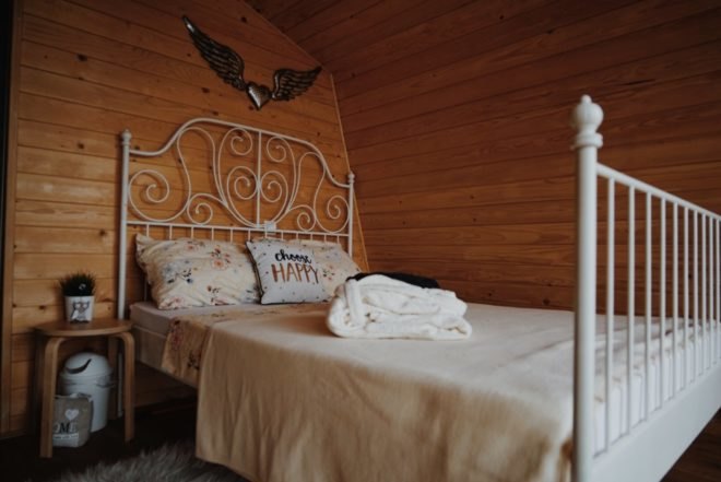 a wood-lined bedroom with white bedding