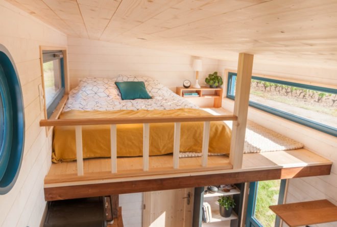 sleeping loft with yellow bed and wood railing