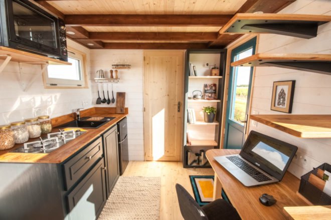 compact kitchen with dark gray cabinets and butcher block countertops