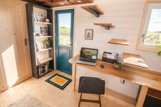 teal front door with desk beside it