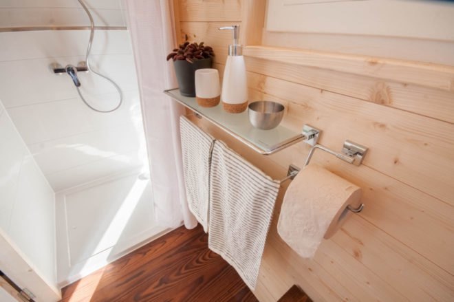 bathroom with stand-up shower and small glass shelf