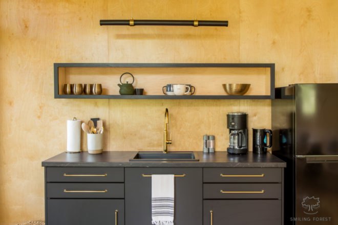 wood-lined kitchen with gray cabinets and shelves