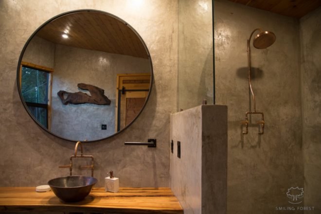 a round mirror in a gray bathroom