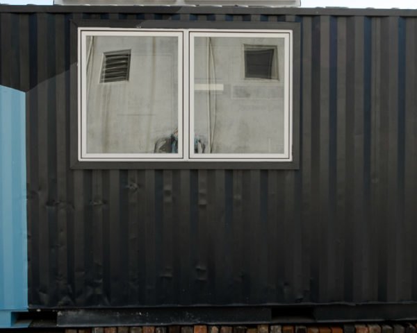 blue and black shipping container with window and white door