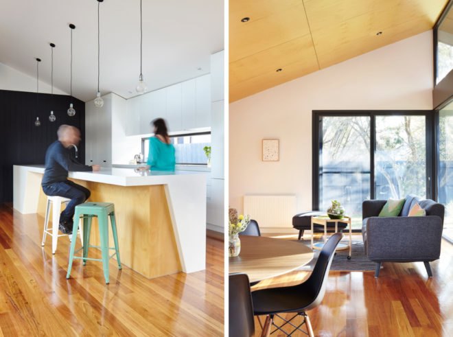 open-plan living room and kitchen with white walls and cabinets, wood floors and a gray couch