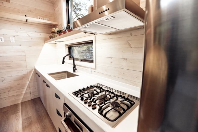 wood-lined kitchen space with stove top and sink