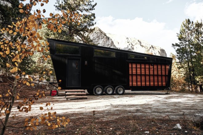 black RV with windows and wooden paneling