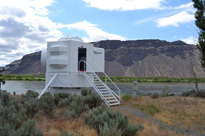 white spaceship-shaped tiny home near mountains