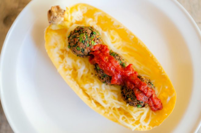 half of a spaghetti squash with meatballs and tomato sauce