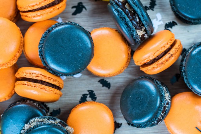 Orange and black macaroons on a table