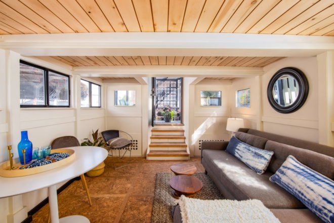 living room with high ceilings, eggshell walls and a gray couch