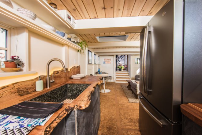 a kitchen with live edge counter and dark refrigerator