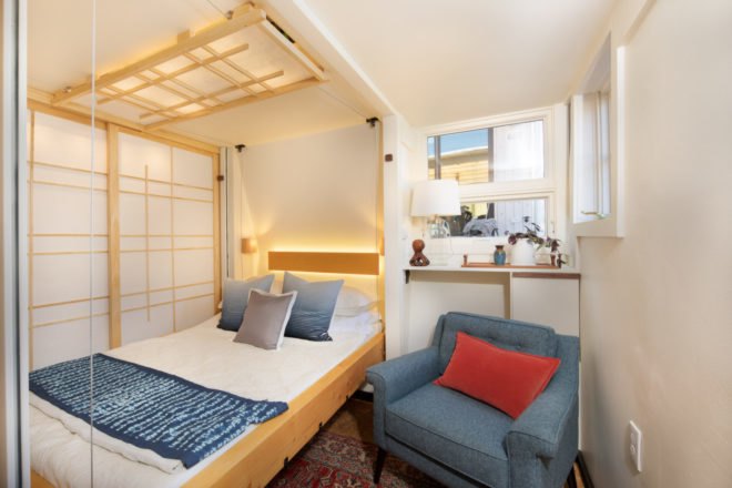 a bedroom with an elevator bed and blue chair