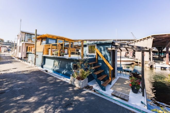 a blue and wood houseboat on a dock