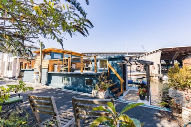 a blue houseboat on a dock