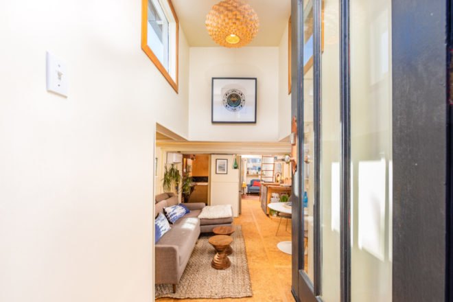 entrance to living area with tall ceilings and wall art