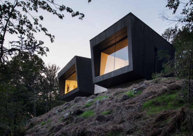 two black boxy cabins with glass facades