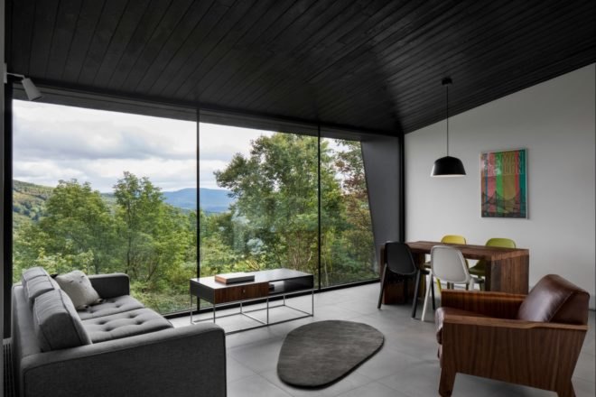 living room with glass facade and a gray couch