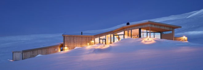 long wood cabin on snowy hill at night