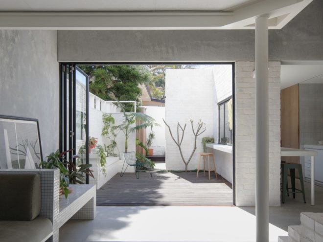 concrete room with large opening that leads out to deck