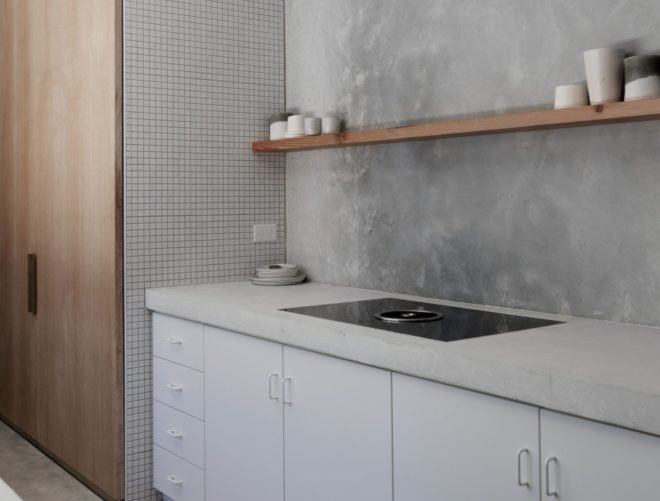 white and gray kitchen space with wooden shelf