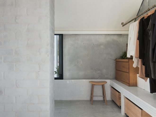 bathroom with concrete walls and clothes hanging on a rod