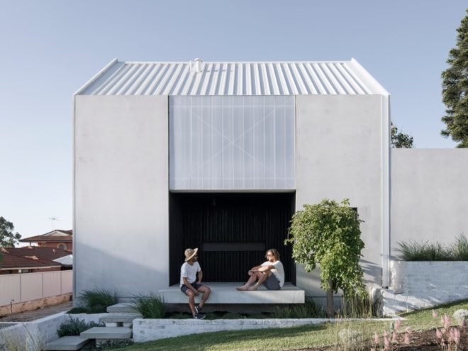 concrete home with two people sitting in a large entryway