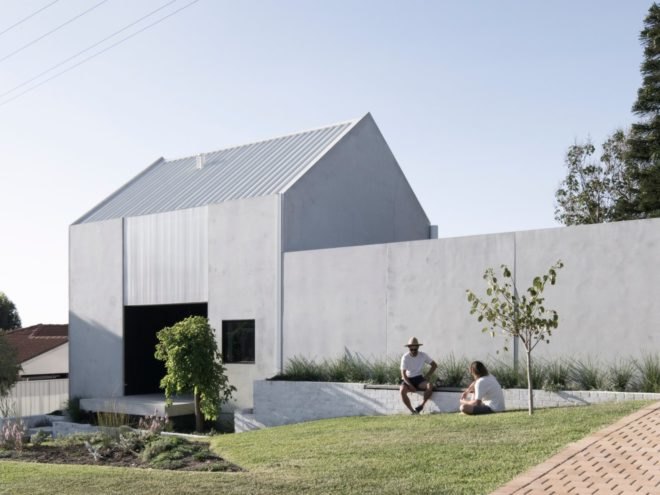 concrete home with two people sitting on a ledge