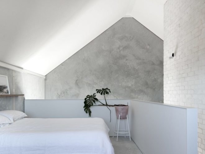 concrete walls with white bed