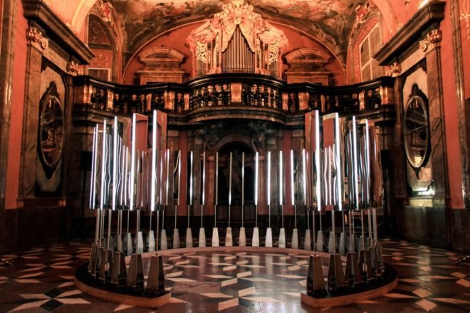 circle of mirrors and lights in dark chapel