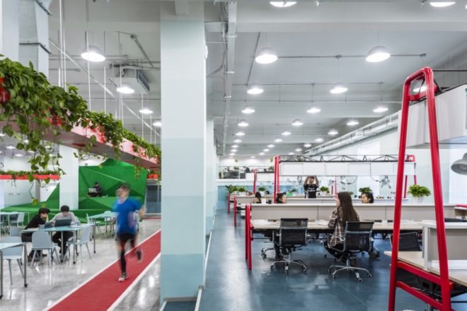 people sitting at tables in a large open office