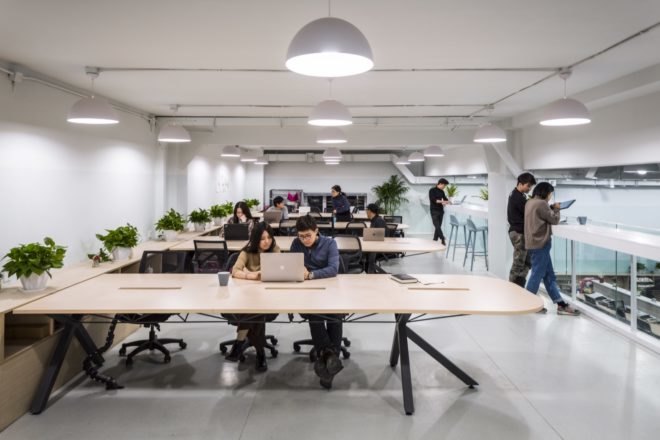 people working on computers at wooden desks