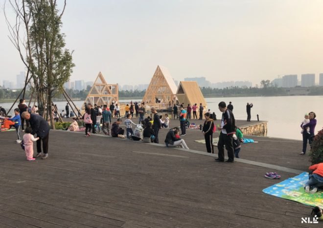 people gathered around floating wood structures