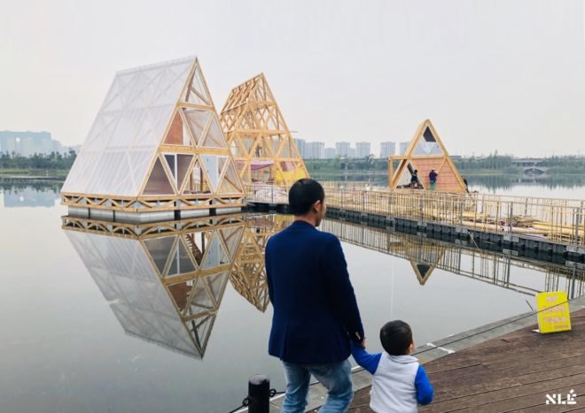 man and child walking near floating wood structures