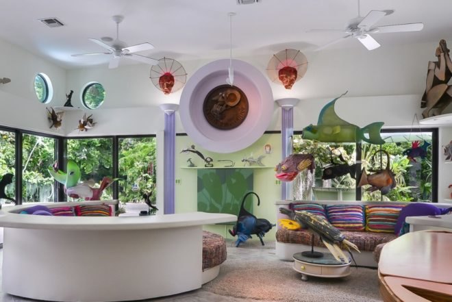 white room with rounded white couch and colorful art throughout