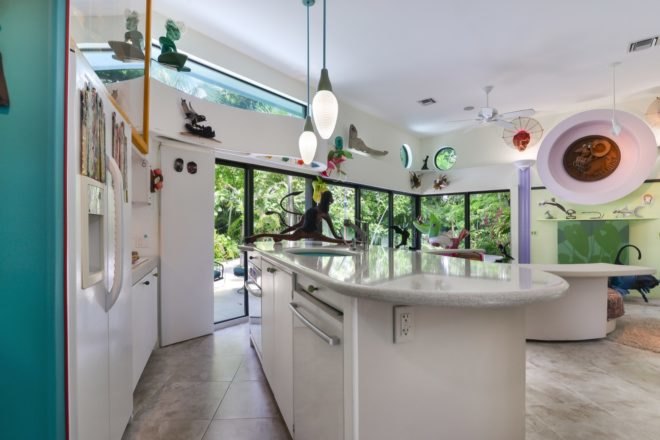 white kitchen island facing room with glass walls